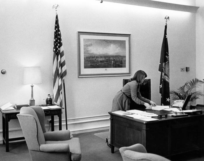 Governor Carey's Secretary Arranges Papers on Desk 