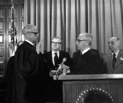 Governor Rockefeller watches a judge being sworn in