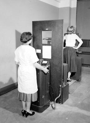 Woman working the X-Ray Machine on Another Woman