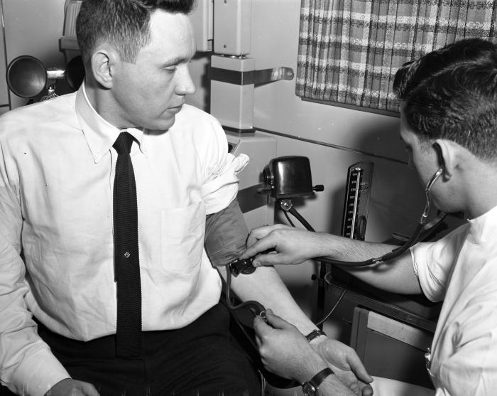 Man having blood pressure checked, 1959