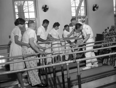 Nurses assisting patients with walking exercises, 1962