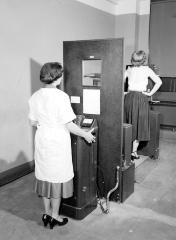 Woman working the X-Ray Machine on Another Woman