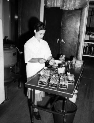 Scientist in a lab filling vials