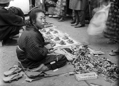 Woman Seated on Matting with Wares Spread for Sale. Kobe, Japan