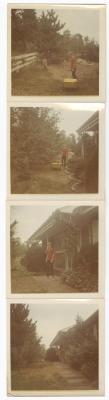 Young man in red shirt and wheelbarrow  standing near house