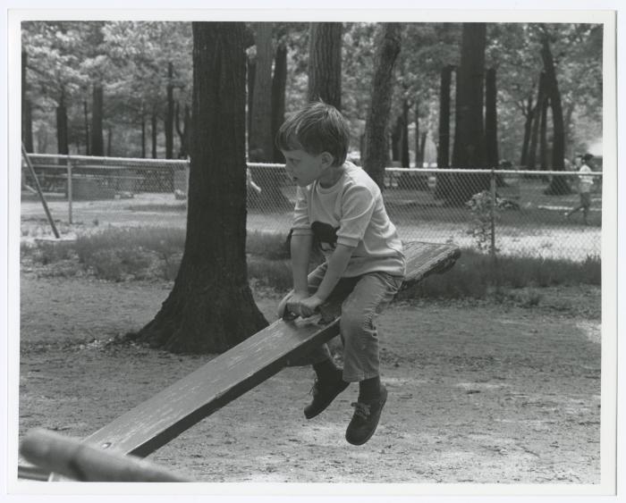 Belmont Lake State Park Playground. Kid on a seesaw