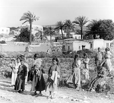 Syria.  Jenin.  Houses, Palm Trees and a Group of Native Women