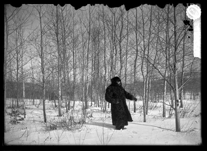 Man in wool coat and hood in forest