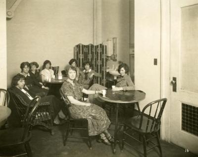 Eight female staff in office break room, 1924