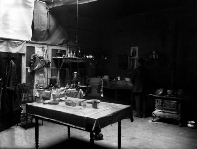 Lifestyle. Immigrant Washing Dishes in Big Room.