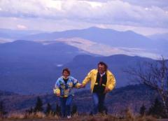 Couple hiking in the Adirondacks, with view of Lake George