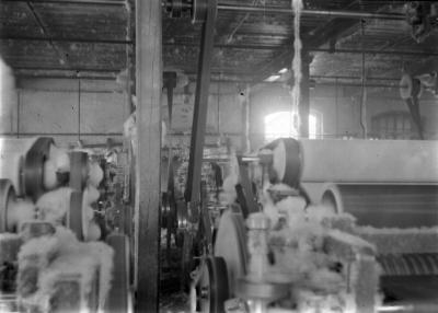 Men's underwear factory:  carding room with machinery, narrow aisles