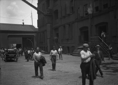 Men in factory yard (noon break?)