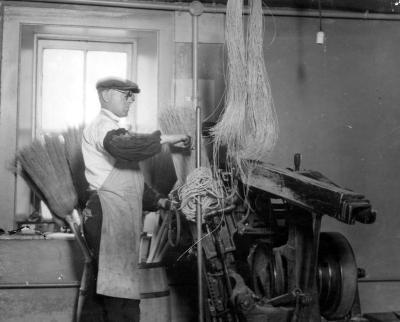NY Association for the Blind. Photograph of man at broom making machinery.