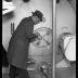 New York City Health Department. Milk inspector examining tags on tank in modern railroad tank car