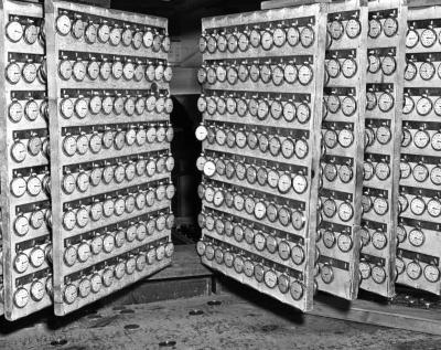 Watches hang on racks to be checked for regulation. Waterbury Watch and Clock Company. Waterbury, Connecticut