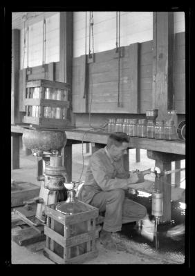 Worker adjusts a valve at the Bayville Bridge experimental shellfish hatchery