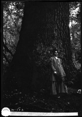 A woman posing in front of a large tree in a Vancouver-area forest