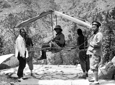 Man being carried in a chair on the trail, Mount Tai Shan