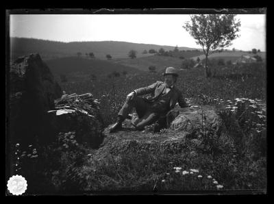 Man sitting on stump in a cleared field