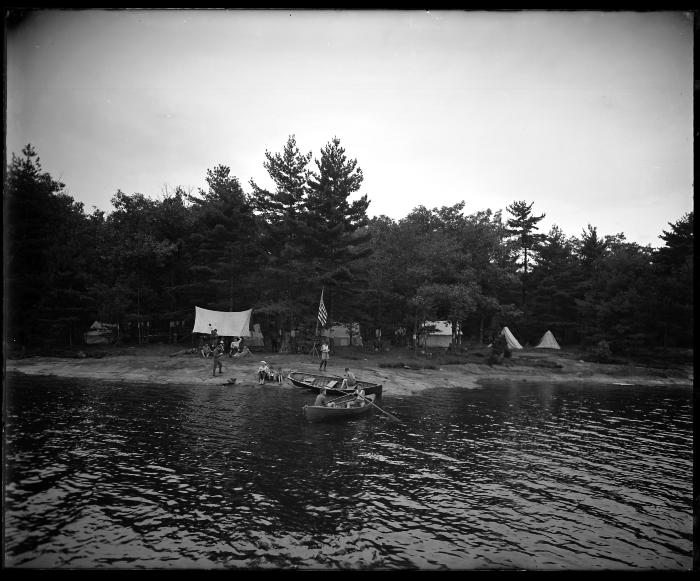 Boys rowing into a boy scout encampment on State Land in Lake George