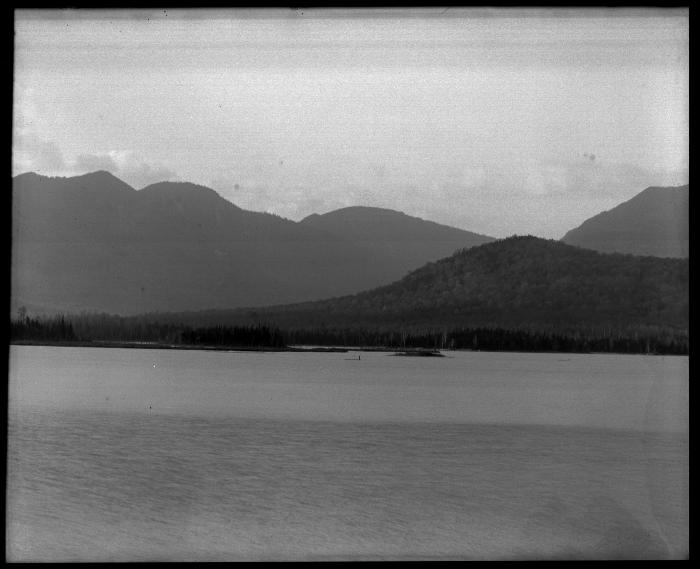 Lake with a small island by shoreline and mountains