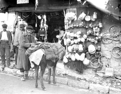 Turkey. Smyrna. Hardware Store; Man with Loaded Donkey